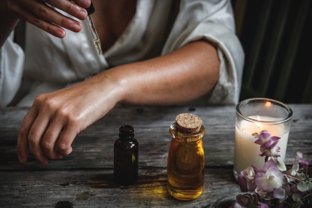 femme utilisant des huiles essentielles pour fabriquer son gel désinfectant