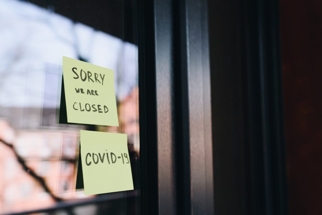 porte magasin fermée avec post-it covid-19 à cause difficultés financières